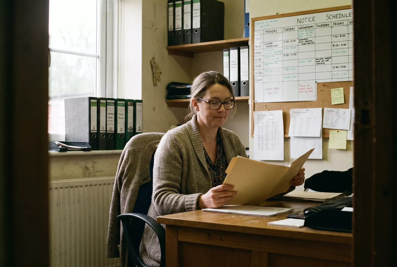 Care agency manager reviewing staff files at her desk